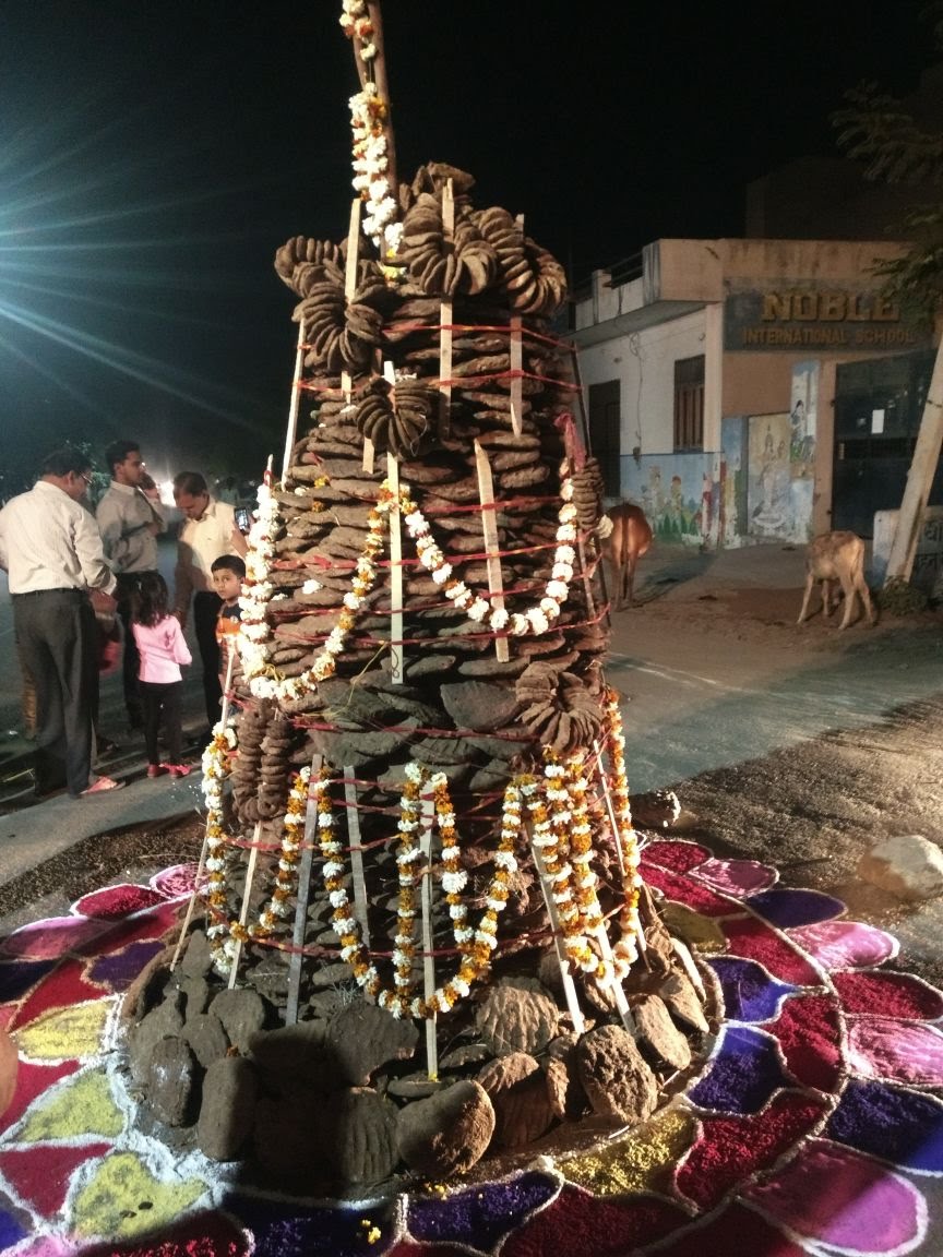 रात्रि दृश्य — फूल-माला एवं रिबनों से सज्जित गोबर-कंडा होलिका