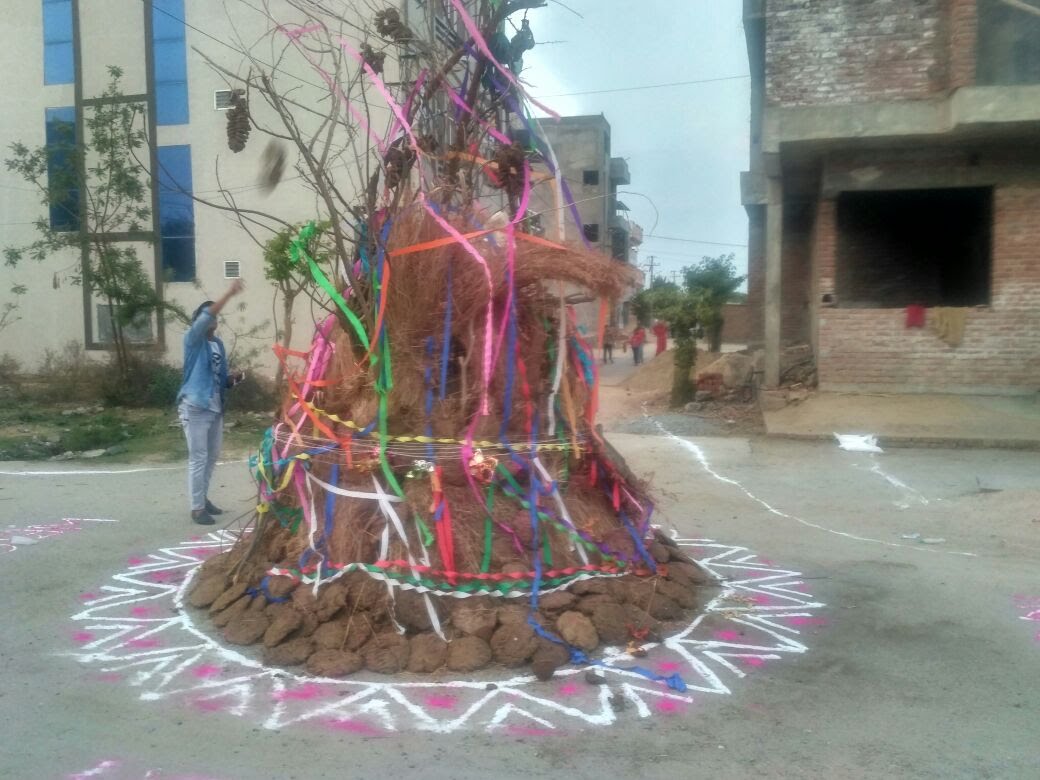गोलाकार गोबर-कंडा टीला — ध्वज-रिबन सज्जा एवं रंगोली